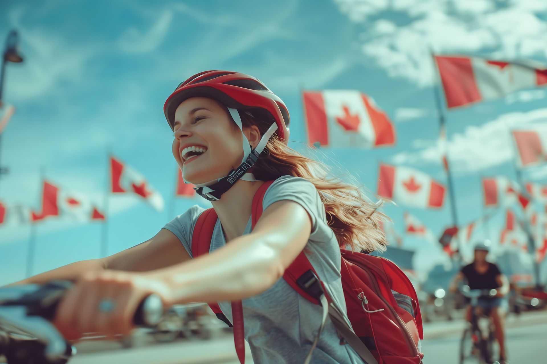 Smiling cyclist in a red helmet rides past rows of red-and-white flags on a sunny street