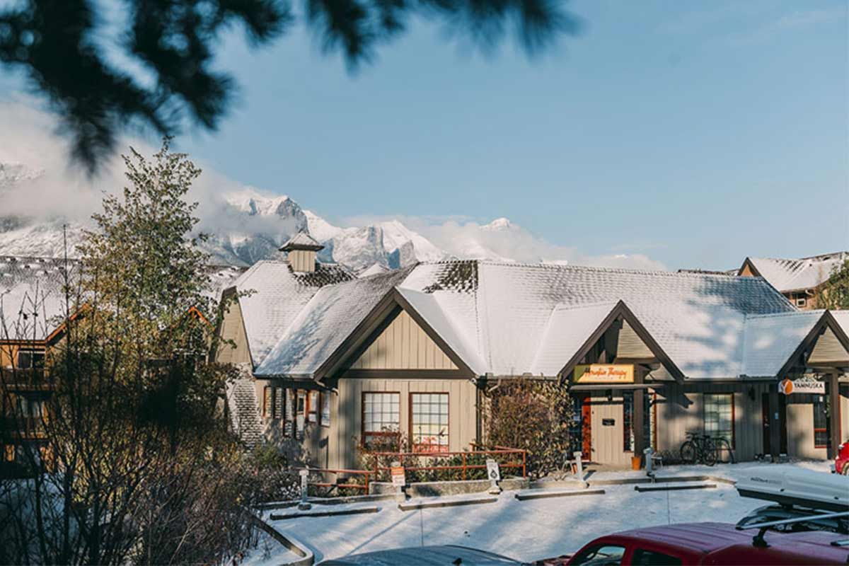 Snow-covered chalet-style lodge with lit windows in a winter mountain setting