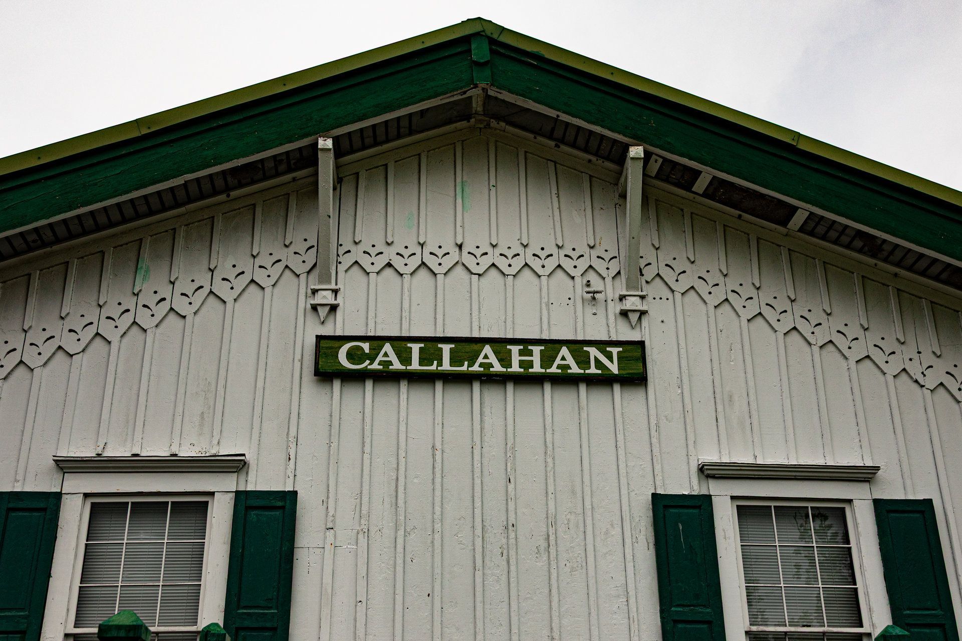 Historic Callahan train depot with its green-trimmed gable and Callahan sign in Callahan, Florida