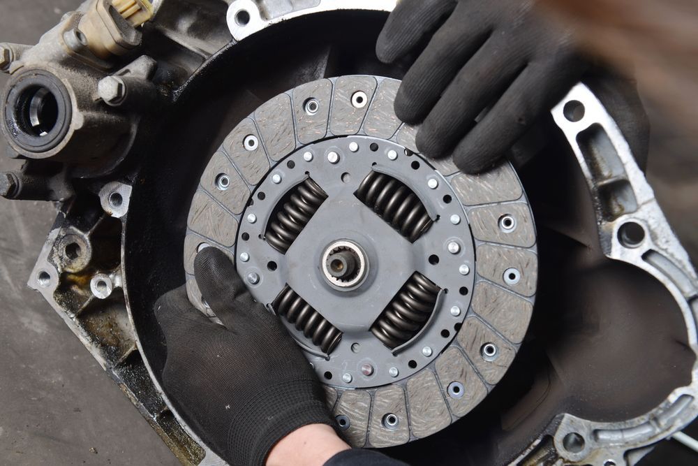 Hands in Black Gloves Installing a Clutch Disc in a Car's Transmission — Mike's Automotive in Edgeworth, NSW