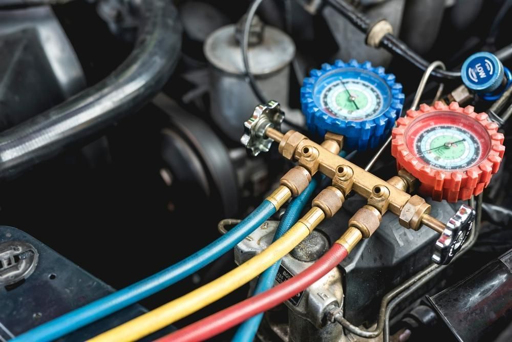 Ac Manifold Gauge Set Connected to a Car Engine, Showing Blue, Red, and Yellow Hoses — Mike's Automotive in Edgeworth, NSW