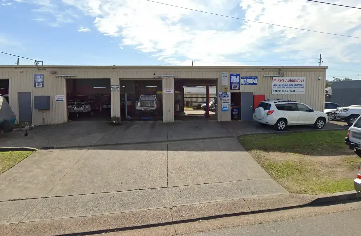 Auto Repair Shop With Three Bays, Vehicles Inside, and a White SUV Parked in Front — Mike's Automotive in Edgeworth, NSW