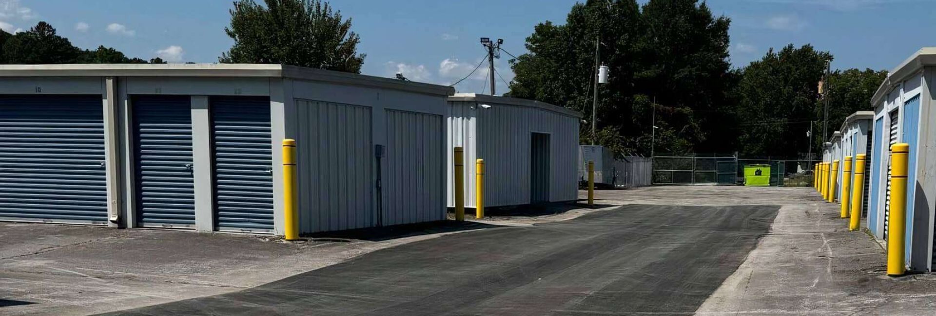Drive aisle lined with blue roll-up storage unit doors at StorMark Self Storage in Midway Park, North Carolina