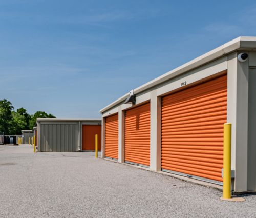 Orange drive-up storage unit doors with a security camera at StorMark Self Storage on US-64 in Asheboro, North Carolina
