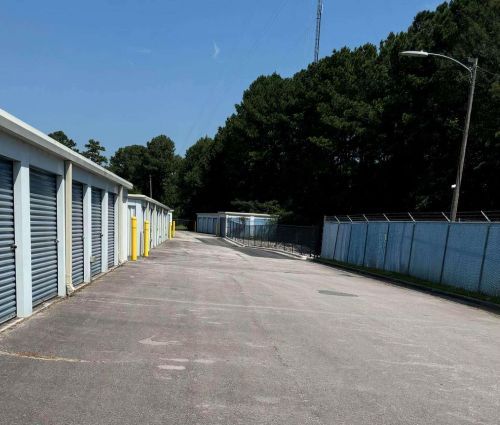 Paved drive lined with blue roll-up storage unit doors at StorMark Self Storage in Midway Park, North Carolina