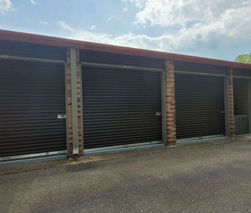 Black roll-up storage unit doors with brick columns at StorMark Self Storage on Jefferson Street in Newnan, Georgia