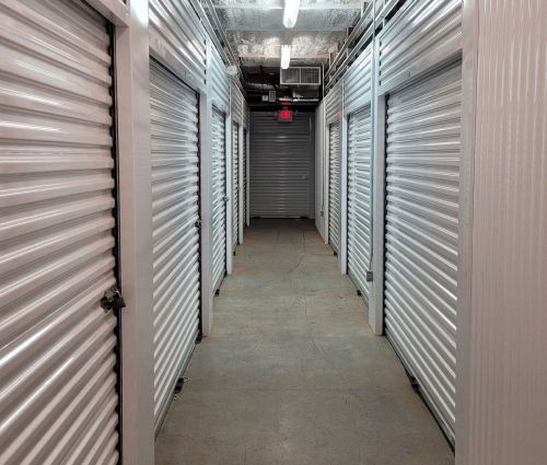 Interior hallway lined with silver roll-up storage unit doors at StorMark Self Storage on South Industrial Drive in Newnan, Georgia