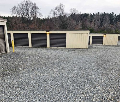 Beige storage buildings with black roll-up doors at StorMark Self Storage in Reidsville, North Carolina