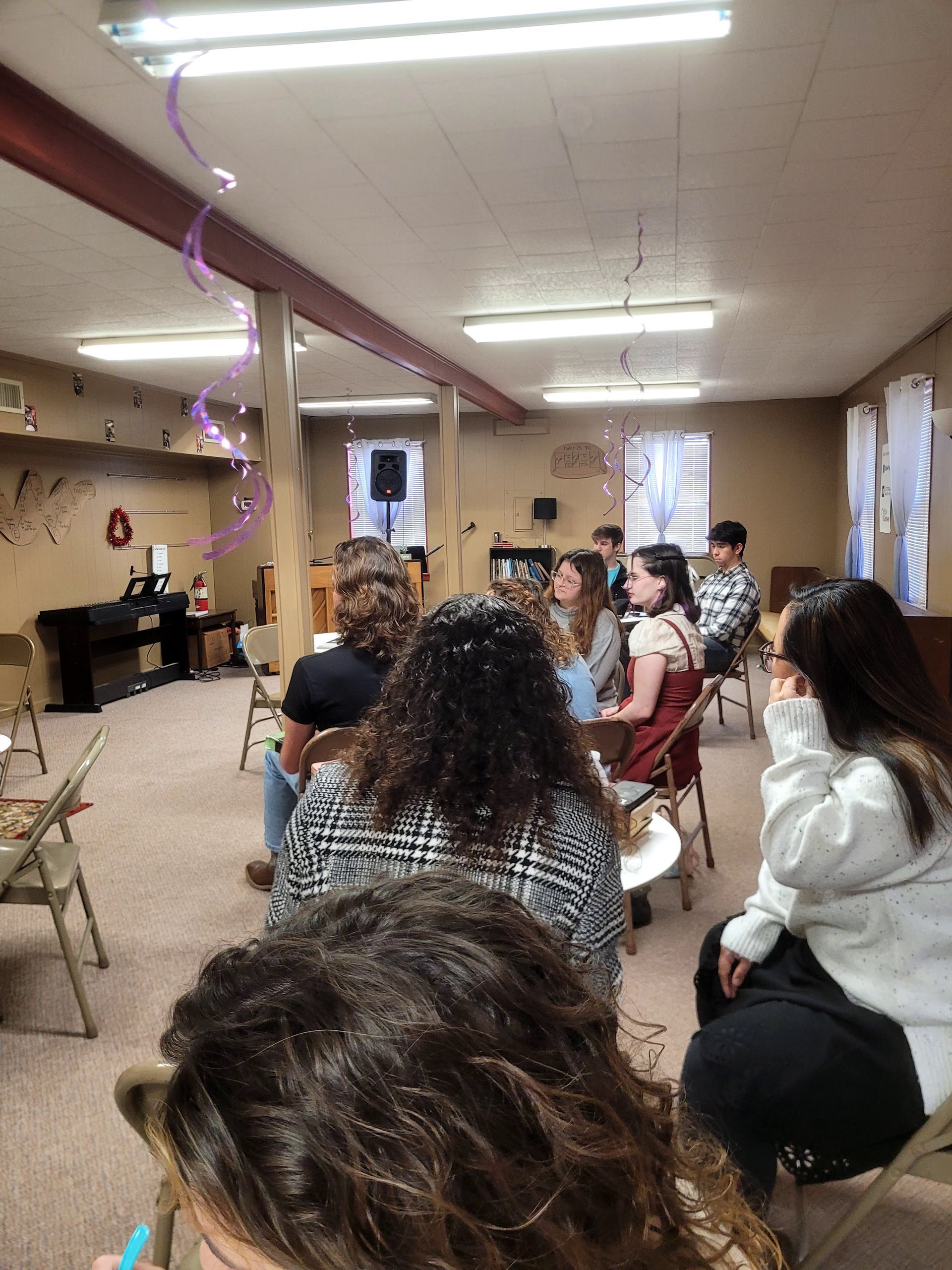 A group of people are sitting in chairs in a room.