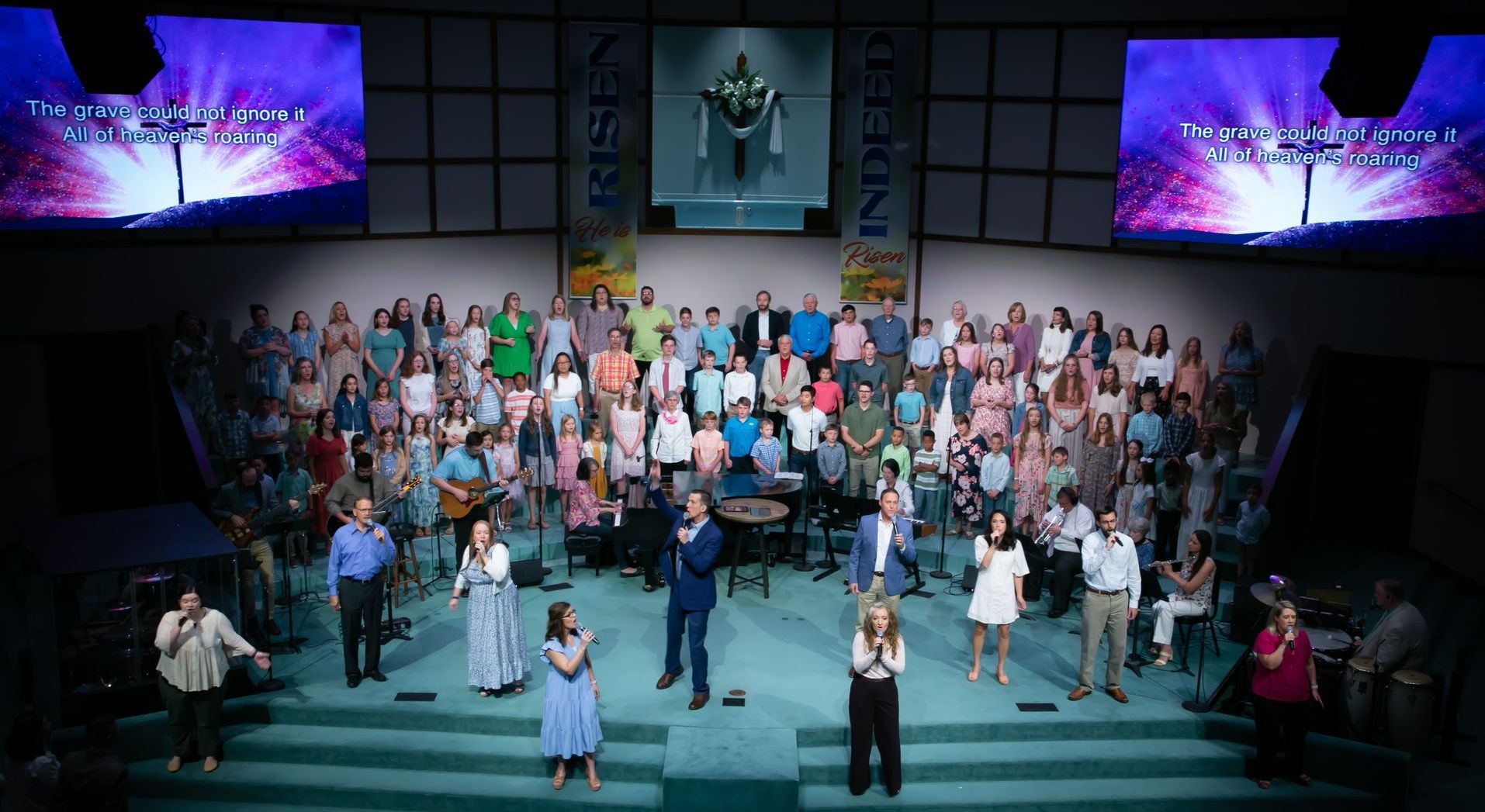 A choir of people standing on a stage