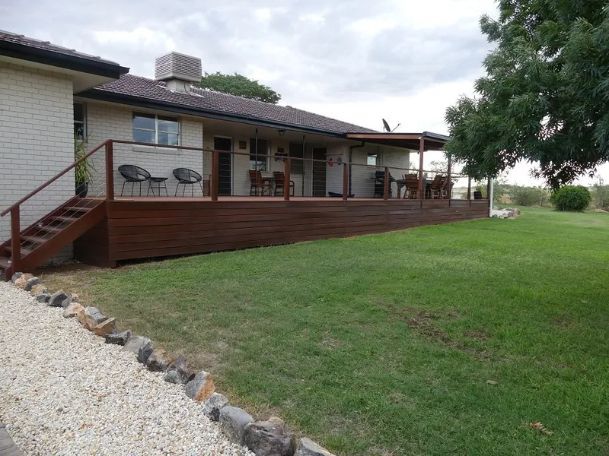 A house with a large deck and stairs in front of it.