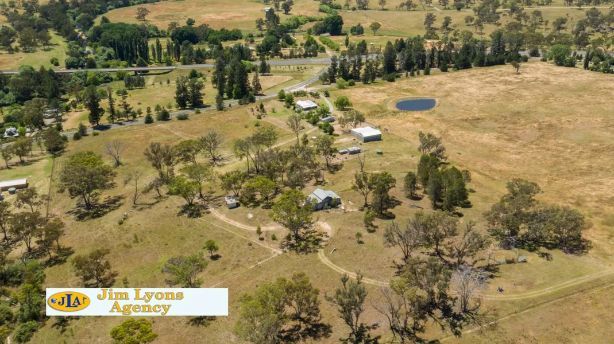 An aerial view of a field with trees and a sign that says jim leone agency