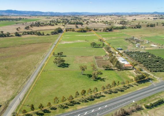 An aerial view of a farm with a road going through it.