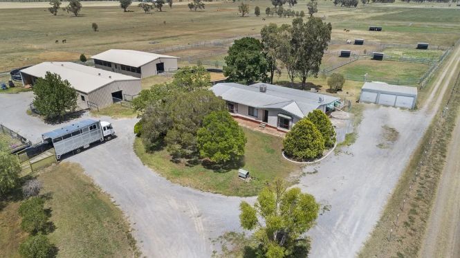 An aerial view of a farm with a truck parked in front of a house.