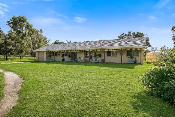 A house with a large lawn in front of it and a path leading to it.