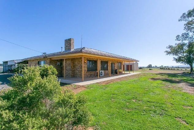 A large house is sitting on top of a lush green field.