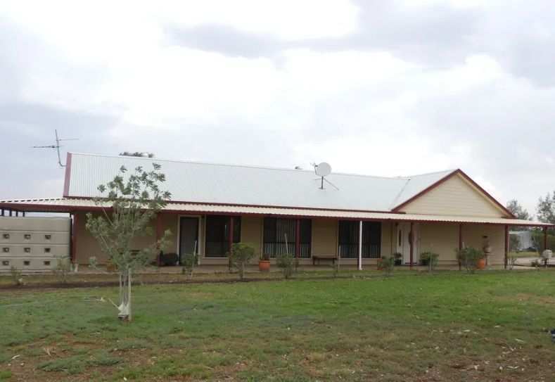 A large house with a porch and a satellite dish on the roof