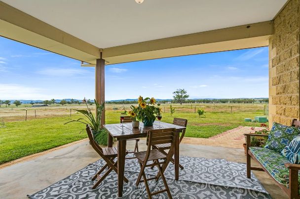 A patio with a table and chairs and a rug.