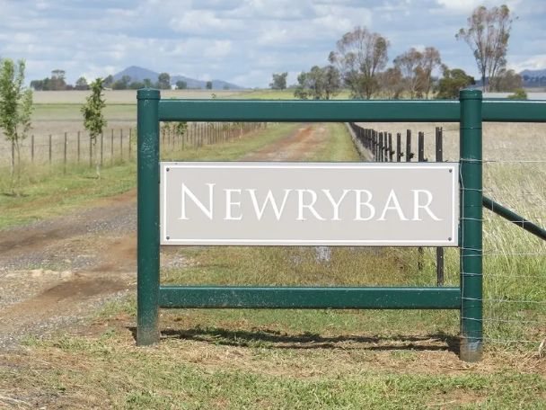 A green fence with a sign that says newrybar