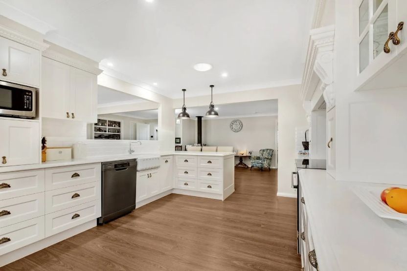 A kitchen with white cabinets and a black dishwasher.