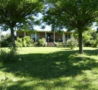 A house with a large lawn and trees in front of it