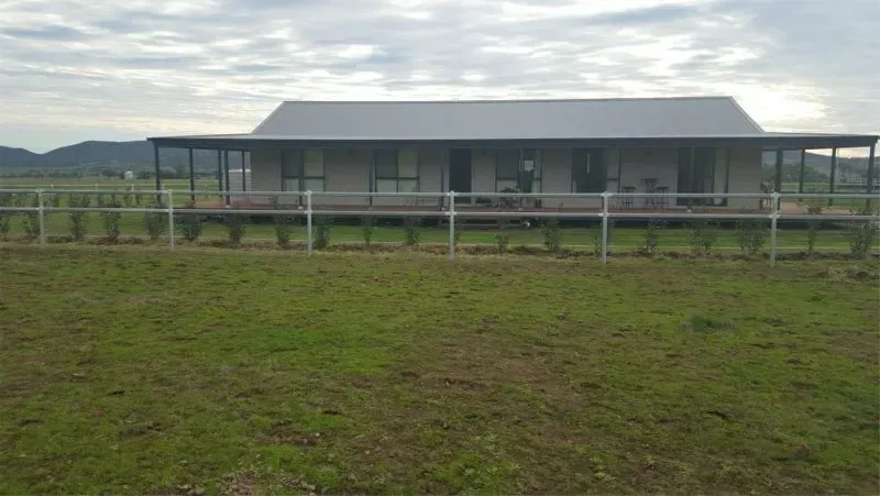 A house with a porch and a fence in front of it