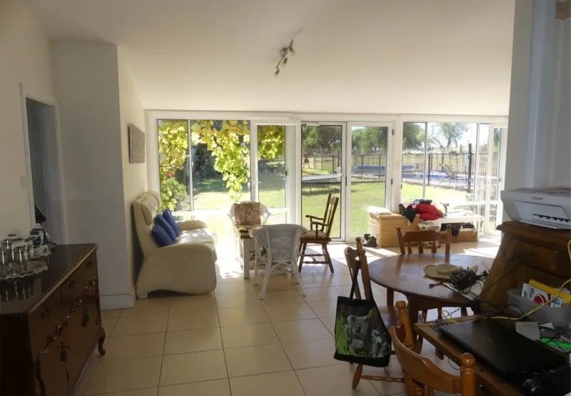 A living room with a lot of windows and chairs