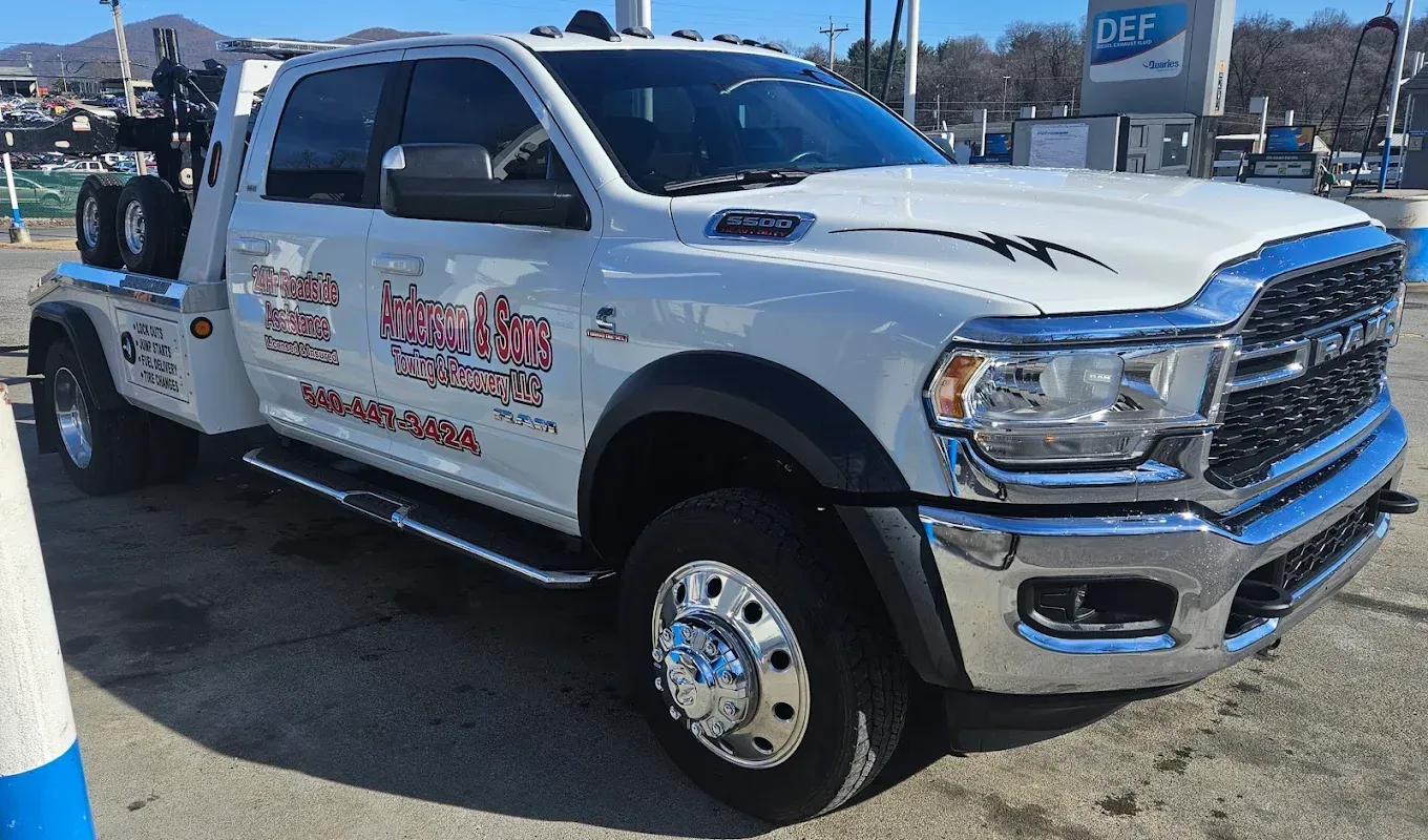 White heavy-duty tow truck with red graphics parked outdoors on a sunny day.