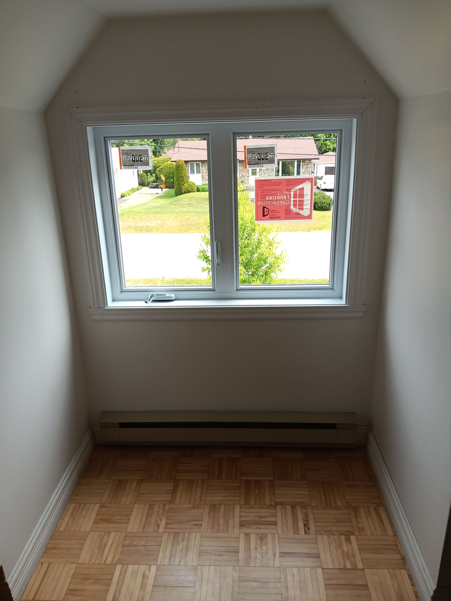 Une petite pièce avec une fenêtre et un parquet