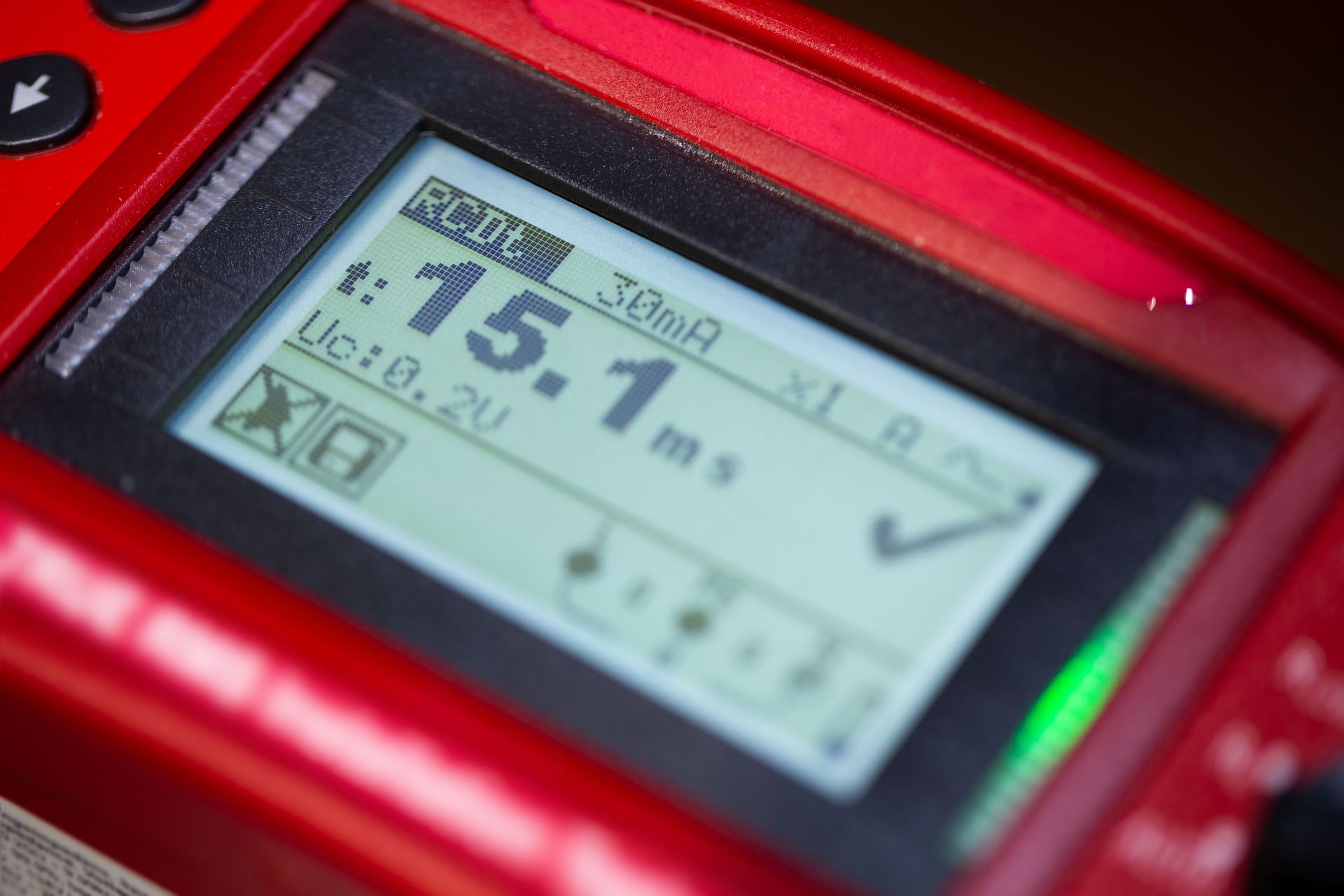 Close-up of a red handheld device screen displaying 16.7 m with a check mark
