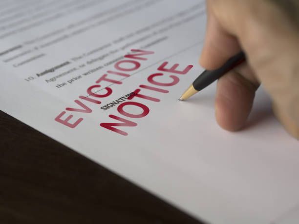 Man signing signing an eviction notice