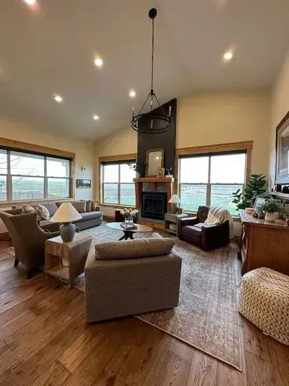 Spacious, warmly lit living room with large windows Spacious, warmly lit living room with large windows
