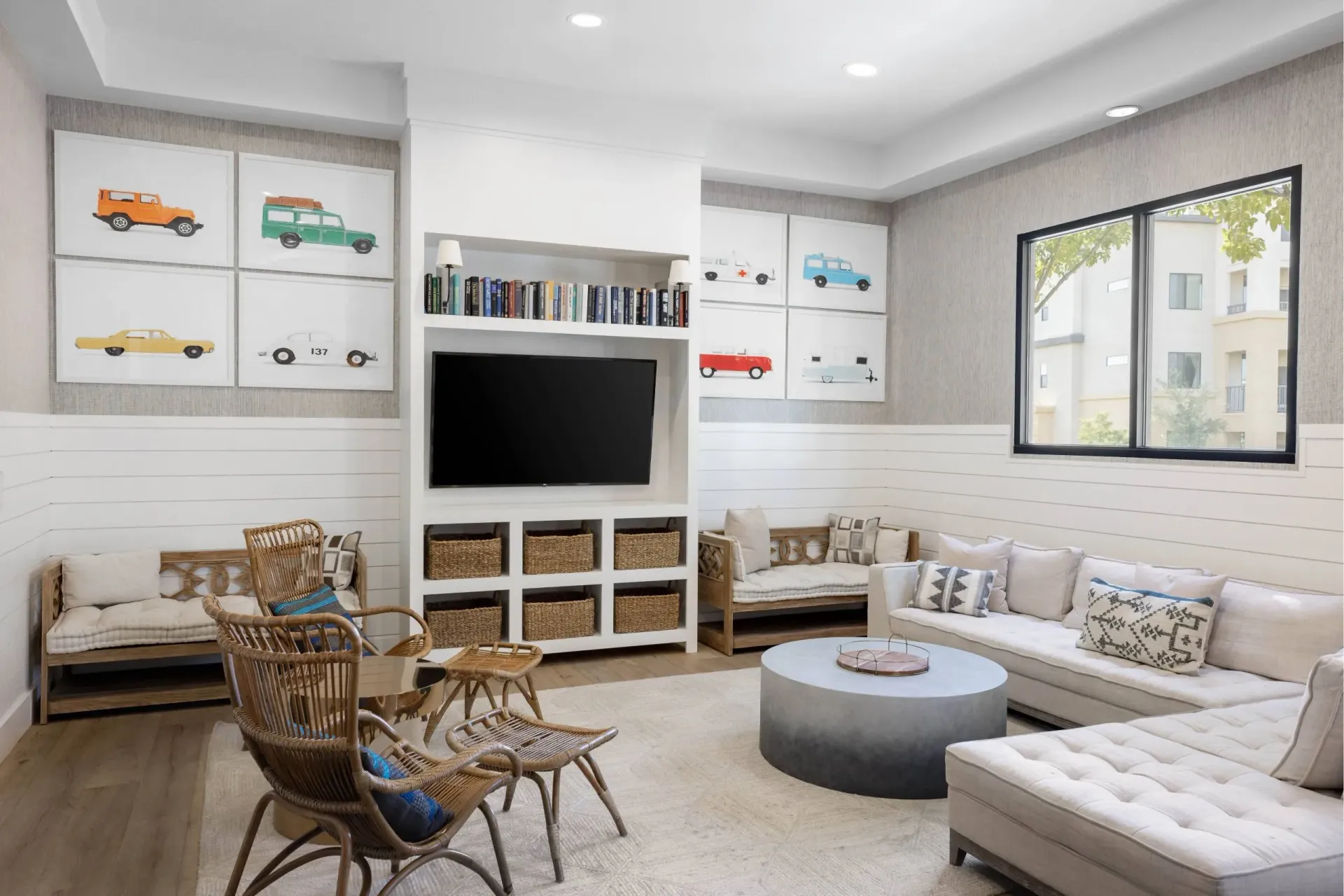 Resident Lounge with a white couch, a grey ottoman, a wooden coffee table, and a television at Cadia Crossing offers apartments in Gilbert, AZ, near Gilbert Town Square.