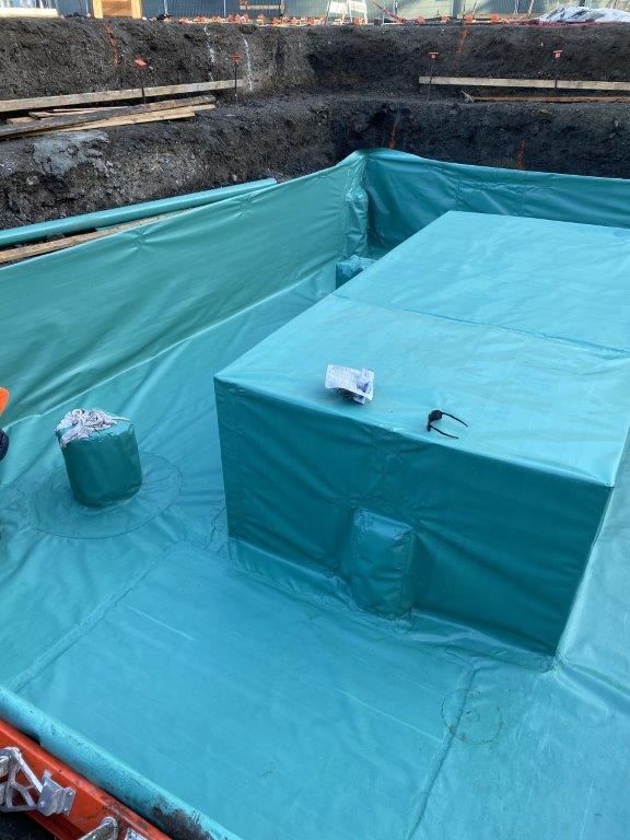 A large green tarp is covering a large hole in the ground. | Oakland, CA | Diablo Roofing