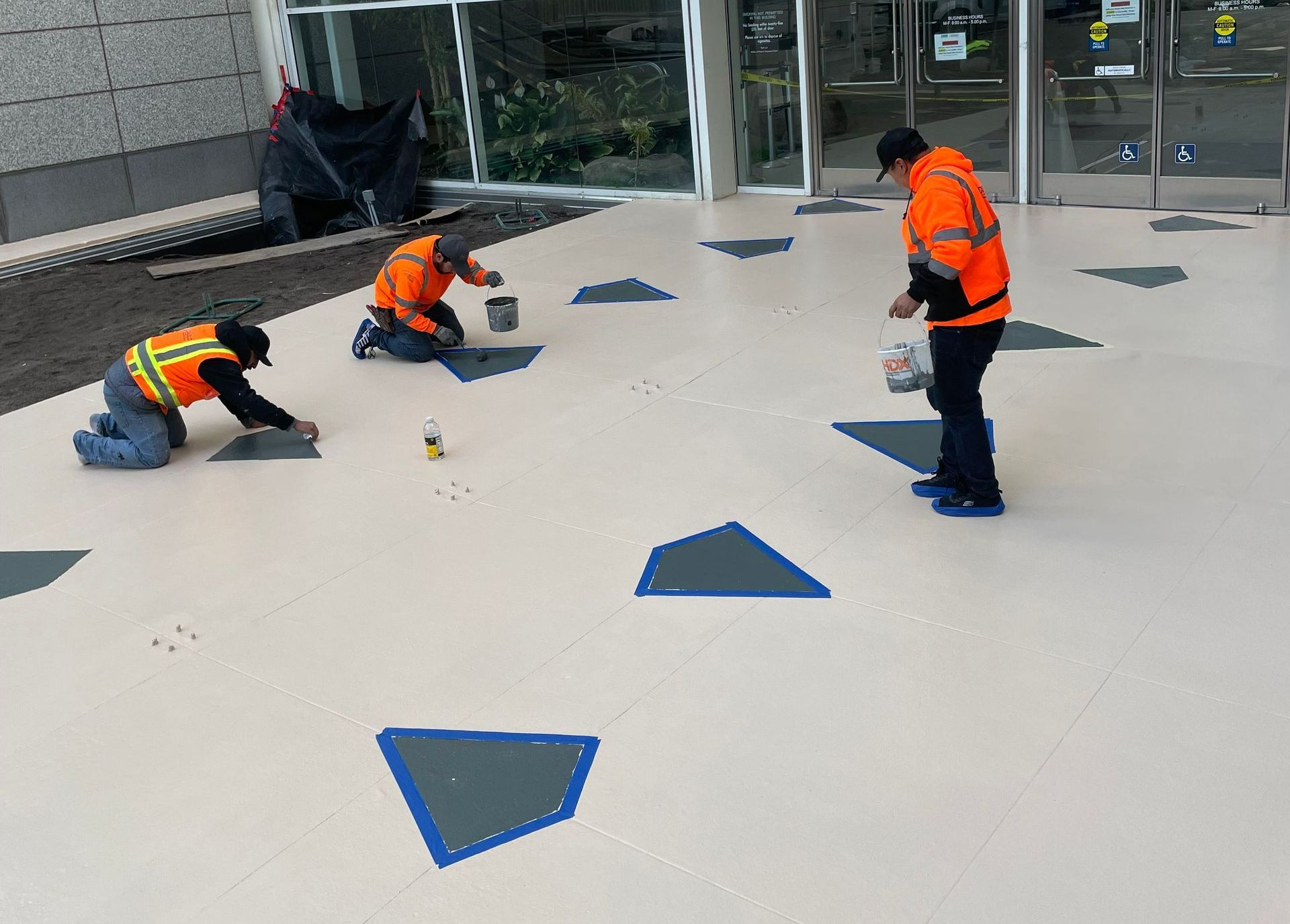Three men are working on a tiled floor in front of a building. | Oakland, CA | Diablo Roofing