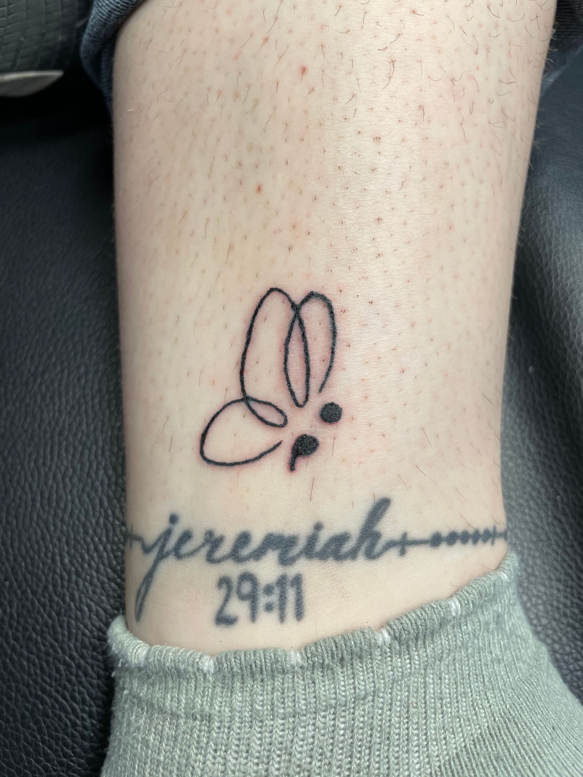 Tattoo of a bunny and the name “Jeremiah” with “29:11” on a leg