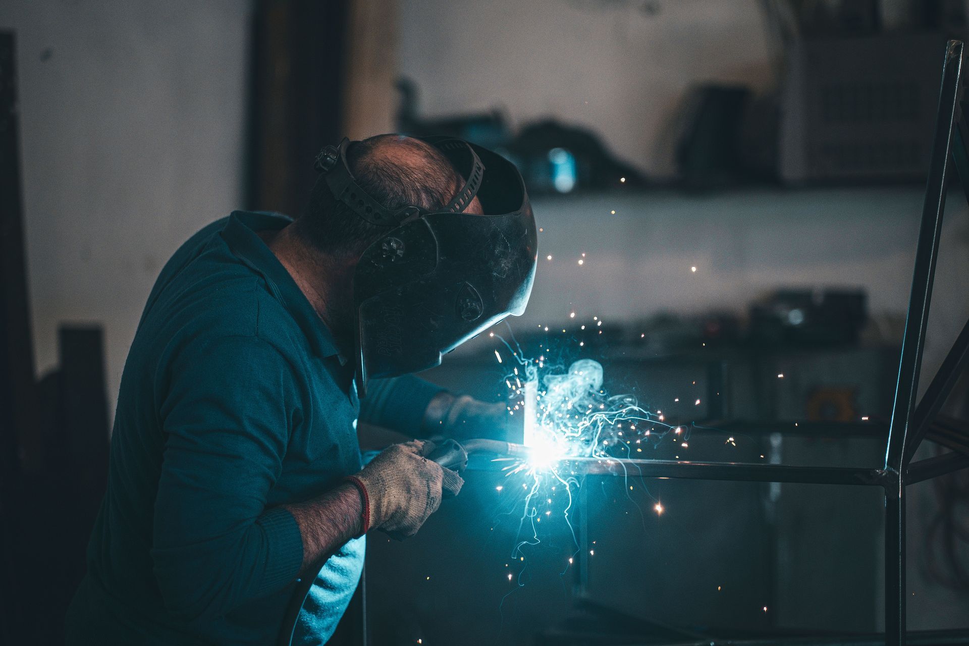 Angle grinder cutting metal, throwing bright orange sparks.