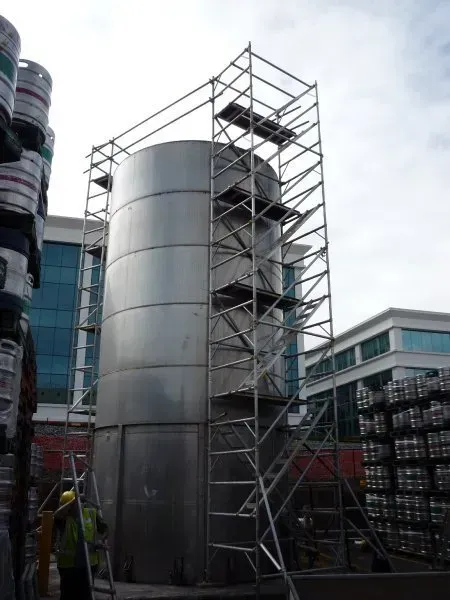 A large metal tank structure with scaffolding around it