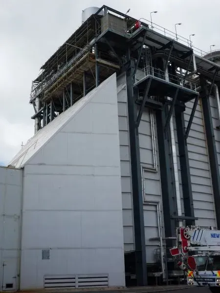 A large building with suspended scaffolding cantilevered from the top of the building