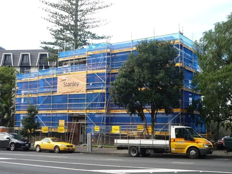 A large scaffold structure that has scrim netting for protection