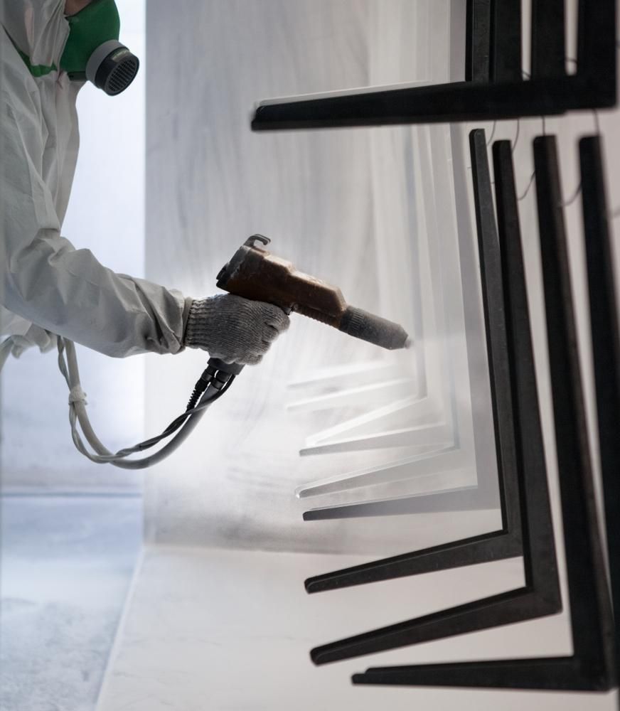 A Man is Painting a Metal With Black — Alamo Powder Coaters in Mittagong, NSW