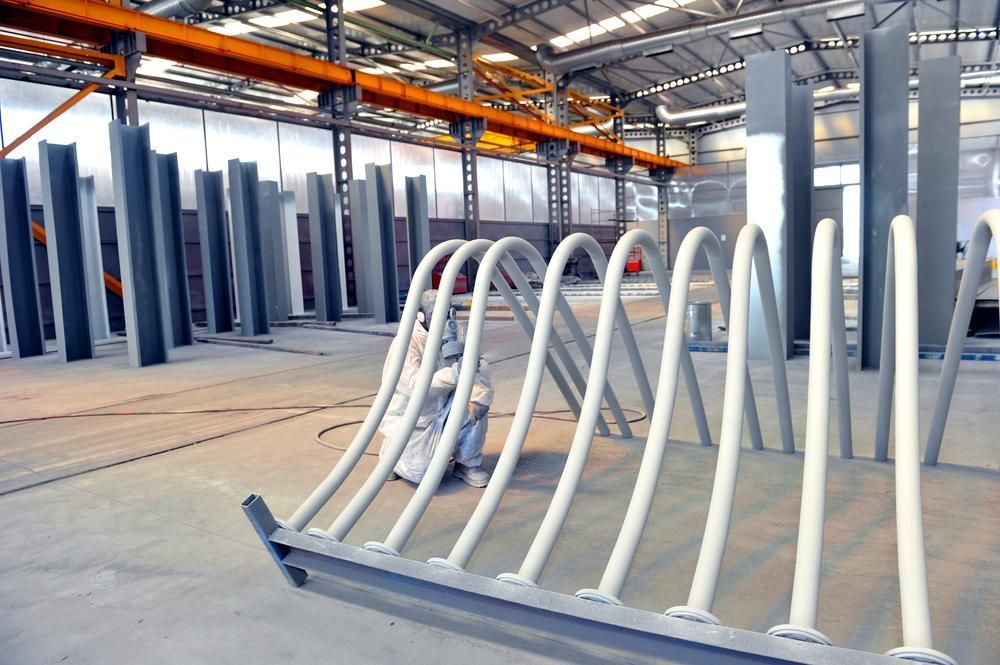 A Row of White Pipes Are Lined Up in a Warehouse — Alamo Powder Coaters in Heathcote, NSW