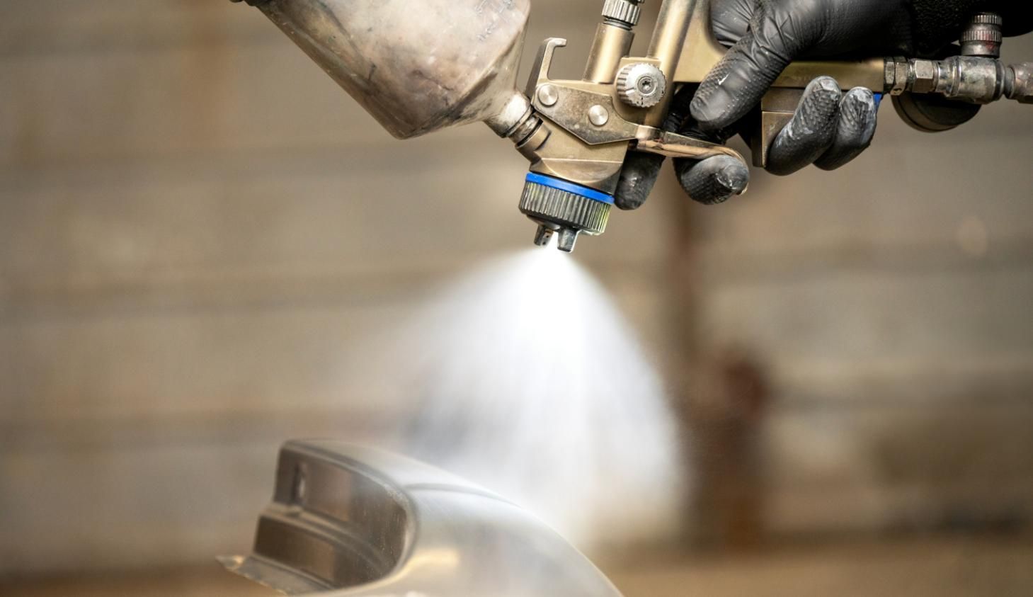 A Person is Spraying Paint on a Piece of Metal — Alamo Powder Coaters in Nowra, NSW