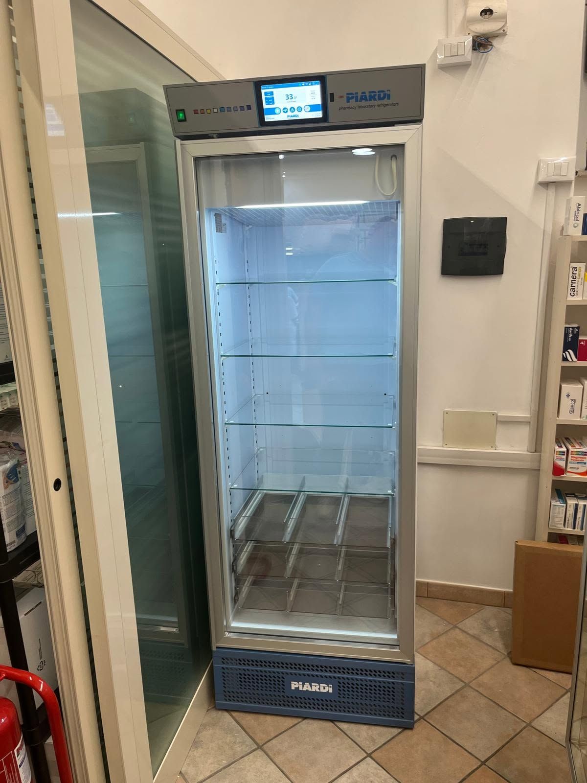 Frigorifero per bevande con porta in vetro in un negozio o in una cucina, con ripiani vuoti e display digitale sulla parte superiore.