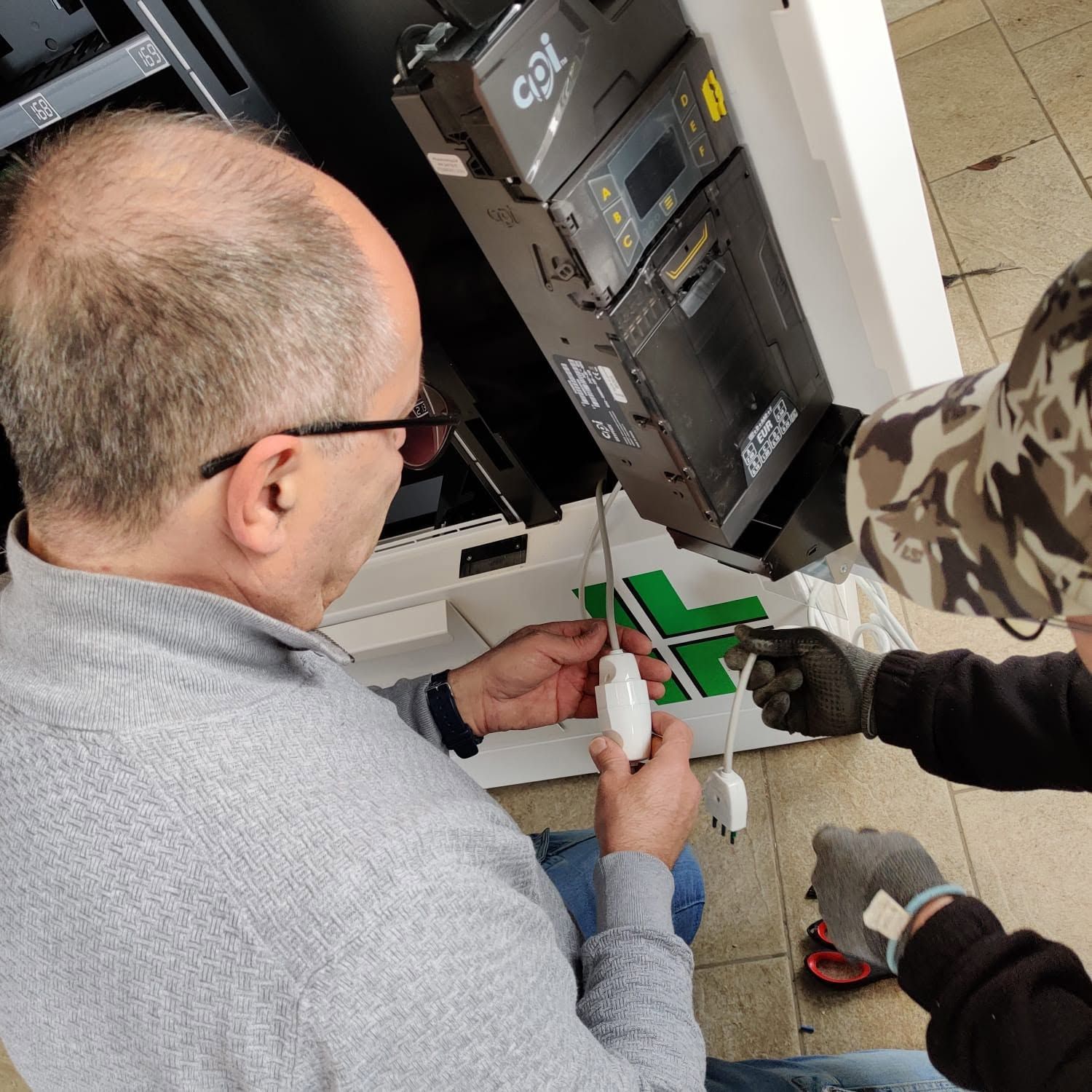 Tecnici che utilizzano strumenti per lavorare su un quadro elettrico aperto all'interno di un edificio.