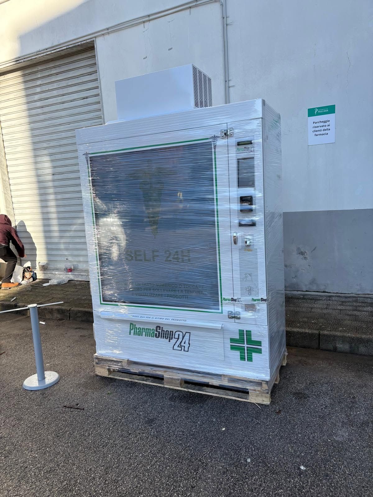 Apparecchiatura medica imballata su un pallet all'esterno di un edificio, vicino a una banchina di carico.