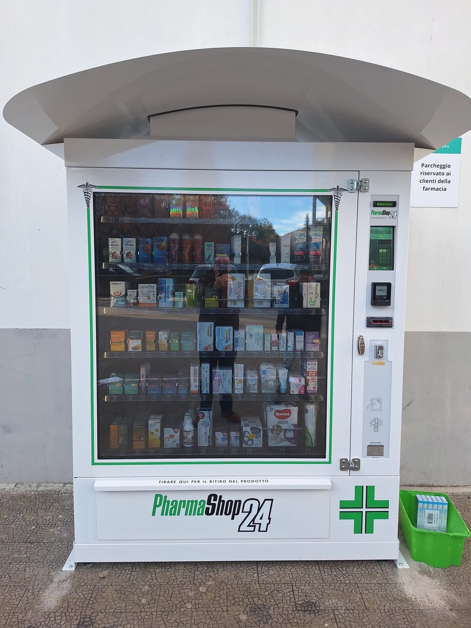 Distributore automatico da esterno con frontale in vetro, struttura bianca e dettagli verdi.