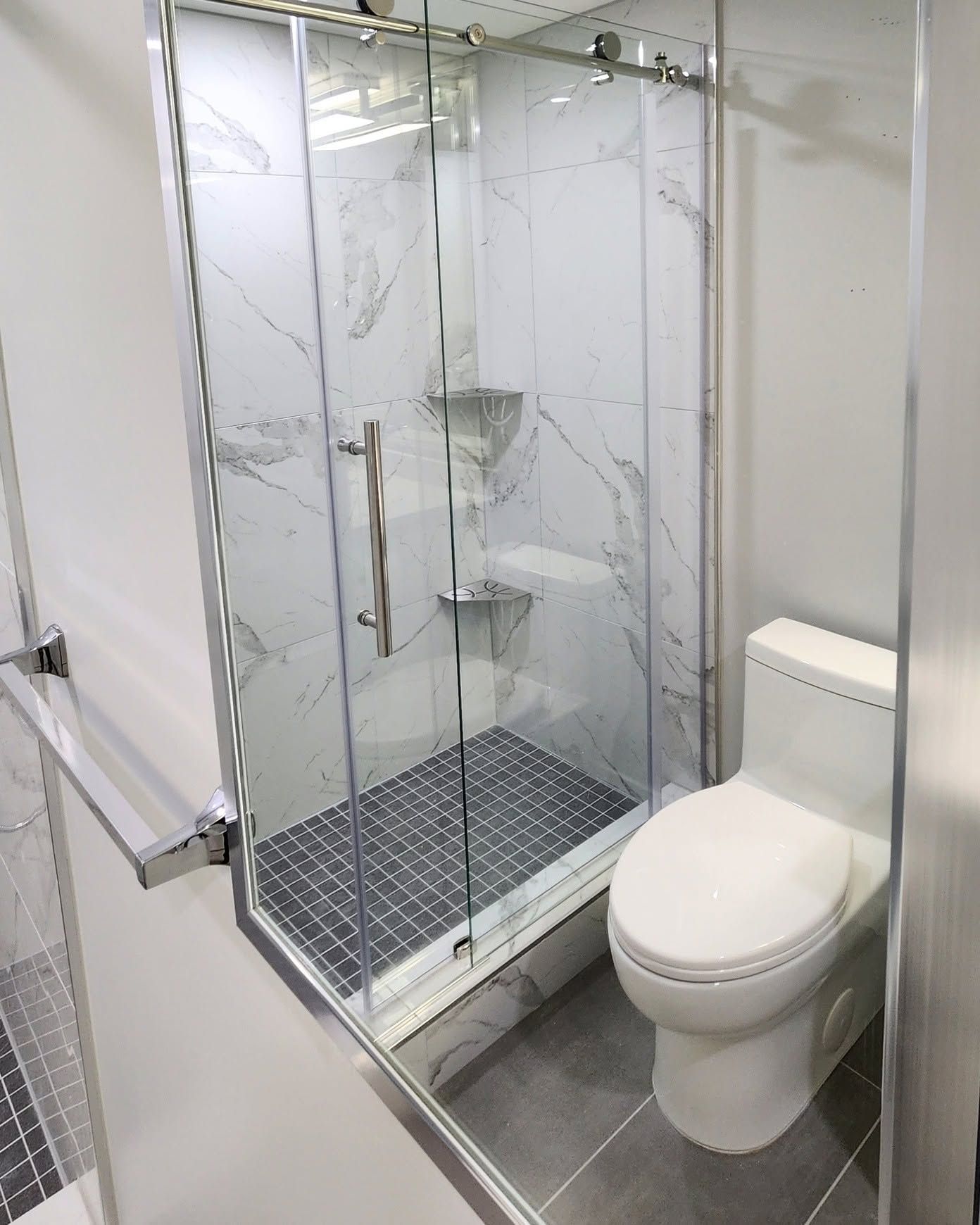 Small bathroom with a glass shower stall and a white toilet beside it.