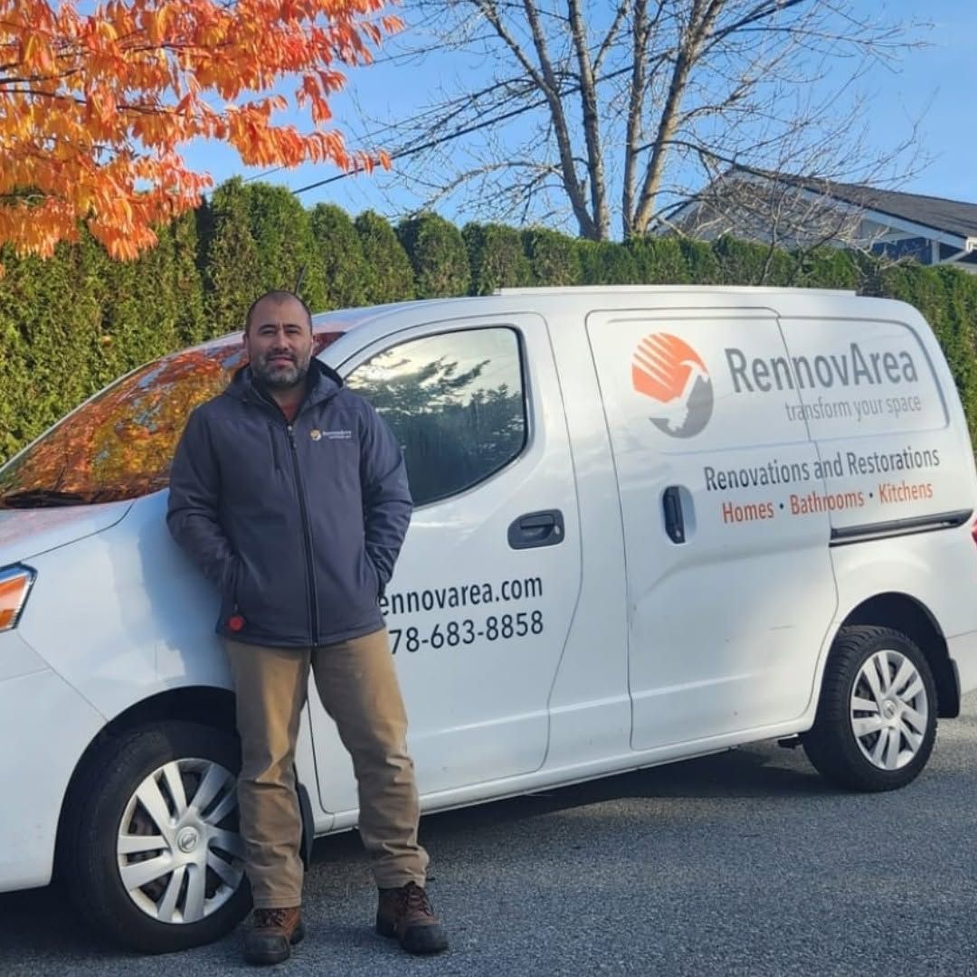 Man standing beside a white RenovaArea service van on a street with autumn trees in the background