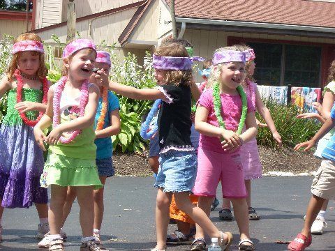A group of young girls are dancing in front of a building
